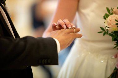 Düğün töreni. Gelinin eli, damadın parmağına yüzük takar. Evlilik yüzüğü..