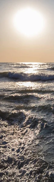 Vertical sea waves and setting sun.