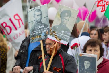 Beyaz Rusya, Gomil şehri, 9 Mayıs 2019. Zafer Günü. Ölümsüz alay. Savaş kurbanlarının akrabalarının portreleri olan bir adam..