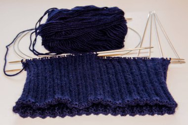 Yün örgü ve iğneler örgü mavi. Örgü şapka.