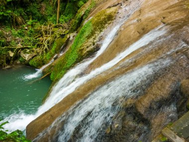Hala güzel, hatta erken düşük akış ile düşmek, üzerinden dökülen ve basamaklandırır yosunlu kireçtaşı uçurumun üzerinden. Şelale