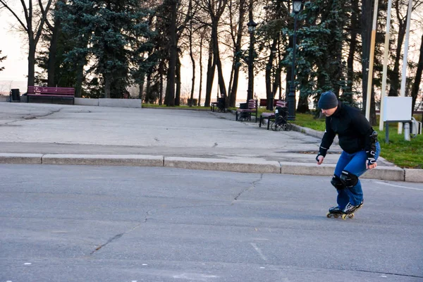 Leisure activity man roller skating in the central of the city on the sunset. Winter. Street roller skating.