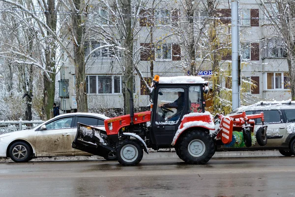 El tractor de nieve monta en un camino nevado y húmedo. Primera nieve. Soplador de nieve . — Foto de Stock