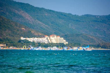 Sanya, Hainan, China - February 20, 2020: Sunny day, sand creaking, clear turquoise sea, coral reefs on the coast of Yalong Bay in South China Sea. Nature Landscape. clipart