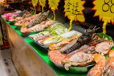 Sanya, Hainan / Çin - 7 Ocak 2020: Çin sokak yemekleri. Sokak ticareti. Çin 'de Sanya, Hainan, Çin' deki Asya deniz ürünleri pazarında taze deniz ürünleri. Yazı: Yemek adı.