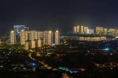 Sanya şehrinin gece görüşü çok renkli aydınlatma binaları, binaları, binaları, yolları, kaldırımları, direkleri, köprüleri. Sanya, Hainan, Çin