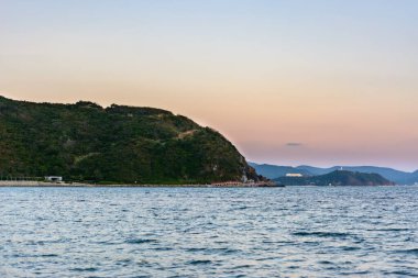 Günbatımı, kum, turkuaz deniz, Güney Çin Denizi 'ndeki Xiaodonghai Körfezi kıyısındaki mercan resifleri. Sanya, Hainan Adası, Çin. Doğa Manzarası.