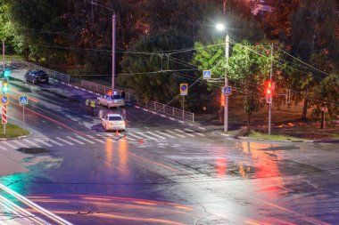 Ulyanovsk, Rusya - 10 Nisan 2020. Gece yol ayrımında, şoför bir yayaya saldırıp onu devirdi. Polis bir trafik kazası hazırladı. Trafik ihlali. Acil durum ışıklarıyla polis müfettişi arabası.