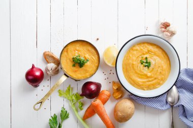 Beyaz ahşap zemin üzerine kavrulmuş kabak ve havuç çorbası
