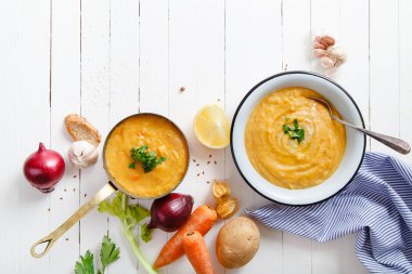 Beyaz ahşap zemin üzerine kavrulmuş kabak ve havuç çorbası