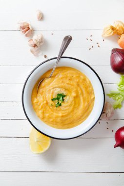 Beyaz ahşap zemin üzerine kavrulmuş kabak ve havuç çorbası