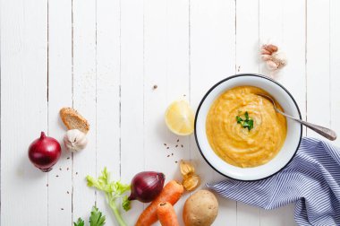 Beyaz ahşap zemin üzerine kavrulmuş kabak ve havuç çorbası