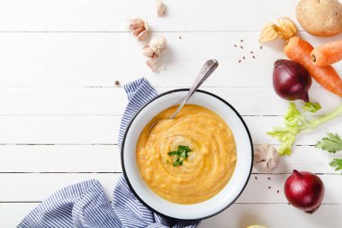 Beyaz ahşap zemin üzerine kavrulmuş kabak ve havuç çorbası