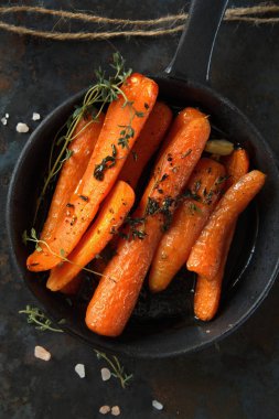 Rustik arka plan üzerinde ağır kızartma tavası ile pişmiş havuç