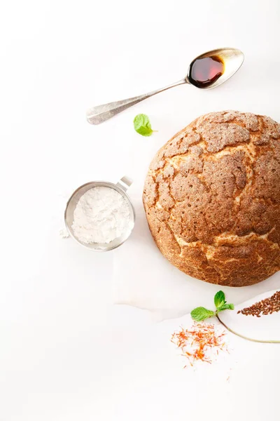 Okrągły bochenek świeżego chleba z przyprawami i mięta na białym tle — Zdjęcie stockowe