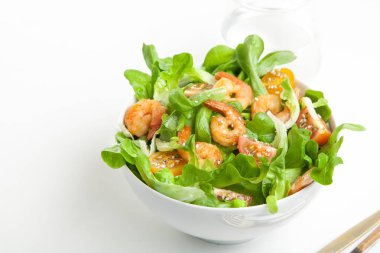 Bir bardak su ile beyaz arka plan üzerinde kase kiraz domatesli karides salatası