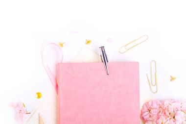 defter, kalem ve pembe çiçekler