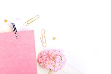 defter, kalem ve pembe çiçekler