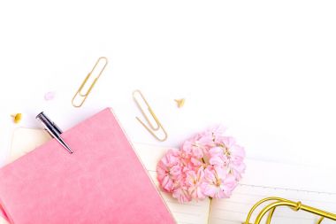 defter, kalem ve pembe çiçekler