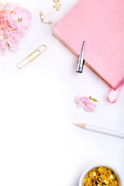 defter, kalem ve pembe çiçekler