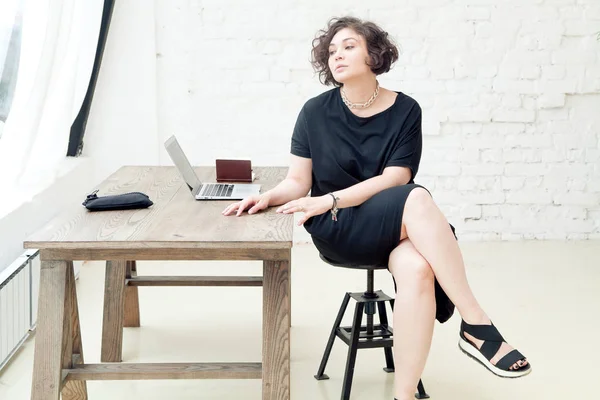 Modelo feminino sentado à mesa — Fotografia de Stock