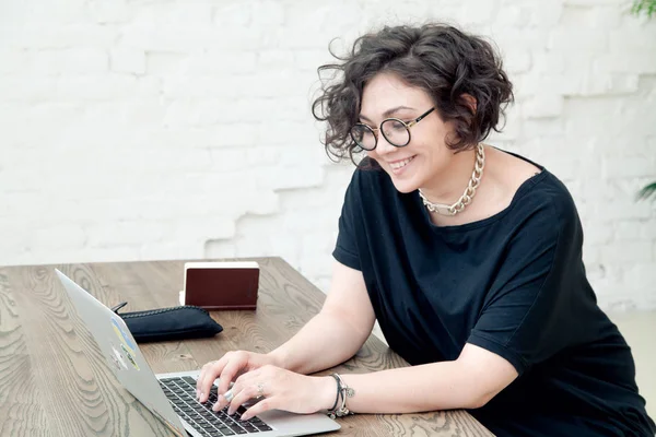 Femme souriante travaillant sur ordinateur portable — Photo