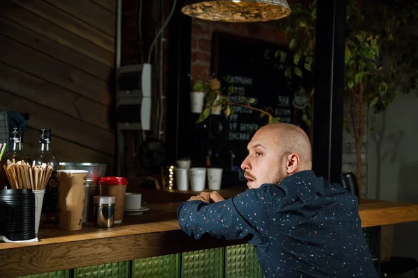 Hombre de moda sentado en el mostrador del bar —  Fotos de Stock