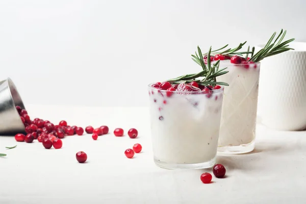 Mükemmel bir Noel kokteyl: kızılcık ve biberiye ile Hindistan cevizi margarita. Minimalist kavramı. Keten kumaş ve beyaz arka plan. Kopya alanı ile yatay kompozisyon.