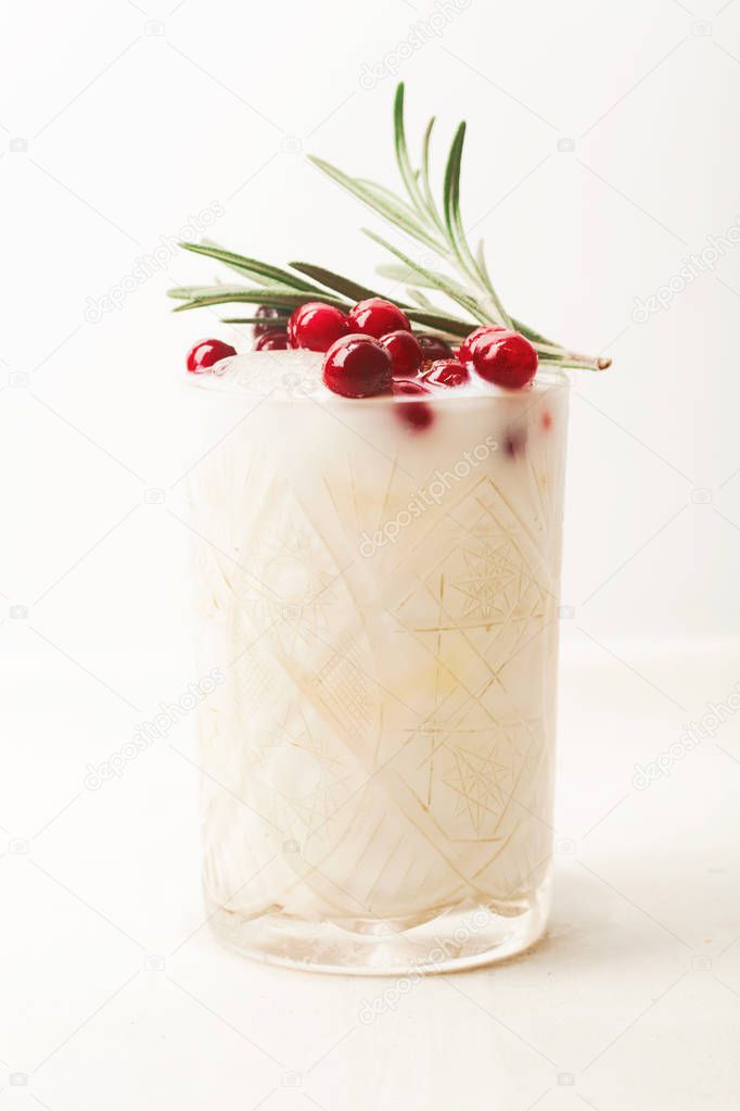 Perfect christmas cocktail: coconut margarita with cranberries and rosemary. Minimalistic concept. Linen cloth and white background.