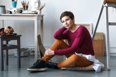 Kadın sanatçı onun geniş beyaz Studio suluboya ile çalışma. Doğal ışık. Yaratıcılık kavramı açıklanması. Yatay kompozisyon.