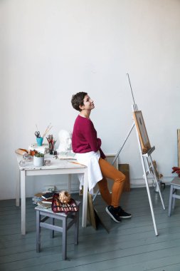 Kadın sanatçı onun geniş beyaz Studio suluboya ile çalışma. Doğal ışık. Yaratıcılık kavramı açıklanması. Kopya alanı ile dikey kompozisyon