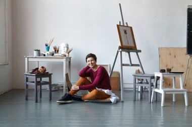 Kadın sanatçı onun geniş beyaz Studio suluboya ile çalışma. Doğal ışık. Yaratıcılık kavramı açıklanması. Yatay kompozisyon.