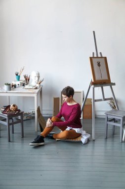 Kadın sanatçı onun geniş beyaz Studio suluboya ile çalışma. Doğal ışık. Yaratıcılık kavramı açıklanması. Kopya alanı ile dikey kompozisyon