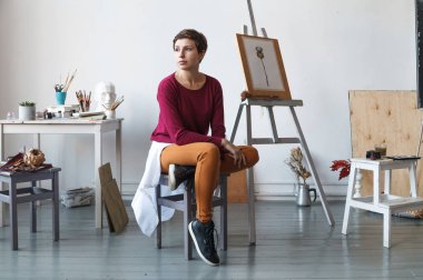 Kadın sanatçı onun geniş beyaz Studio suluboya ile çalışma. Doğal ışık. Yaratıcılık kavramı açıklanması. Yatay kompozisyon.