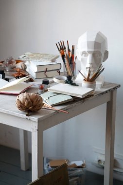 İçişleri Resim Studio serbest sanatçı. Alçı şişe masanın üzerinde sketchbooks ile baş, fırçalar, pencills, mürekkep ve boya. Serbest Sanatçı yaşam tarzı kavramı. Kopya alanı
