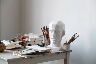 İçişleri Resim Studio serbest sanatçı. Alçı şişe masanın üzerinde sketchbooks ile baş, fırçalar, pencills, mürekkep ve boya. Serbest Sanatçı yaşam tarzı kavramı. Kopya alanı