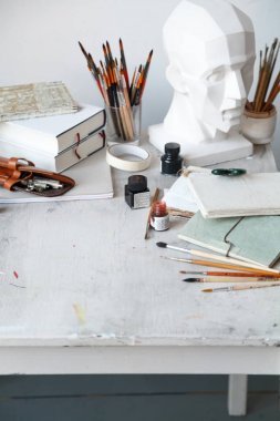İçişleri Resim Studio serbest sanatçı. Alçı şişe masanın üzerinde sketchbooks ile baş, fırçalar, pencills, mürekkep ve boya. Serbest Sanatçı yaşam tarzı kavramı. Kopya alanı