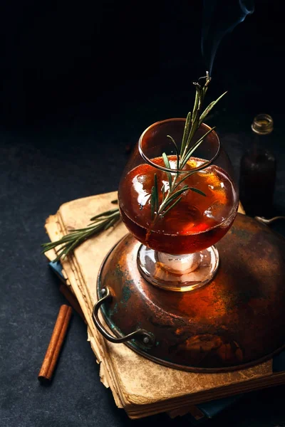 Cóctel Whisky Con Hielo Romero Quemado Fondo Oscuro Papeles Antiguos — Foto de Stock