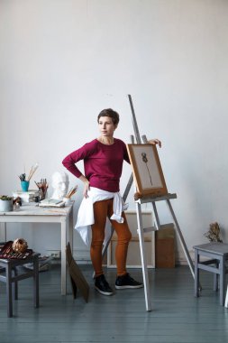 Kadın sanatçı onun geniş beyaz Studio suluboya ile çalışma. Doğal ışık. Yaratıcılık kavramı açıklanması. Dikey kompozisyon.