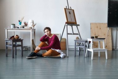 Kadın sanatçı onun geniş beyaz Studio suluboya ile çalışma. Doğal ışık. Yaratıcılık kavramı açıklanması. Yatay kompozisyon.