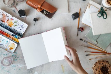 Serbest Sanatçı açılan sketchbook üstten görünüm ile işyeri. Düz yatıyordu kompozisyon kopya alanı ile. Doğal ışık. 