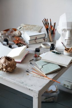 İçişleri Resim Studio serbest sanatçı. Alçı şişe masanın üzerinde sketchbooks ile baş, fırçalar, pencills, mürekkep ve boya. Serbest Sanatçı yaşam tarzı kavramı. Kopya alanı