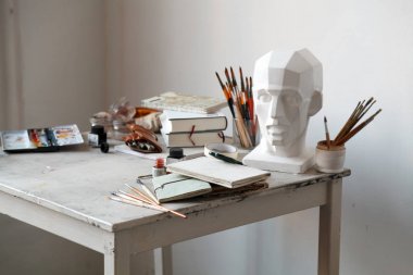 İçişleri Resim Studio serbest sanatçı. Alçı şişe masanın üzerinde sketchbooks ile baş, fırçalar, pencills, mürekkep ve boya. Serbest Sanatçı yaşam tarzı kavramı. Kopya alanı