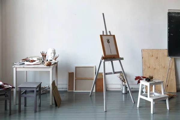 İçişleri Resim Studio serbest sanatçı. Alçı şişe masanın üzerinde sketchbooks ile baş, fırçalar, pencills, mürekkep ve boya. Şövale suluboya resim ile. Serbest Sanatçı yaşam tarzı kavramı. Kopya alanı