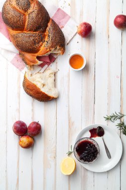 Geleneksel Yahudi ekmek kahverengi challah meyve ve bal ile beyaz ahşap zemin üzerinde. Rustik konsepti. Kopya alanı