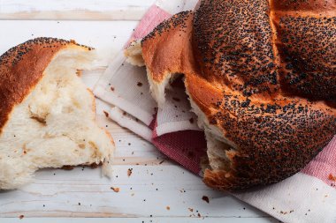 Geleneksel Yahudi ekmeği kahverengi challah beyaz ahşap zemin üzerinde meyve ve bal ile. Kaba bir kavram. Kapat..