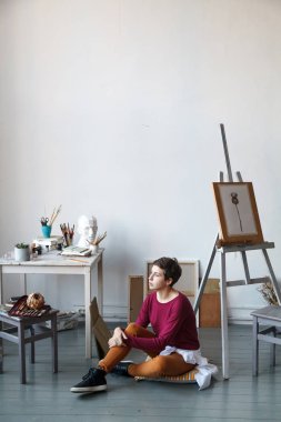 Kadın sanatçı onun geniş beyaz Studio suluboya ile çalışma. Doğal ışık. Yaratıcılık kavramı açıklanması. Kopya alanı ile dikey kompozisyon