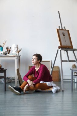 Kadın sanatçı onun geniş beyaz Studio suluboya ile çalışma. Doğal ışık. Yaratıcılık kavramı açıklanması. Kopya alanı ile dikey kompozisyon