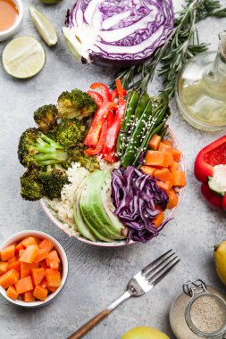 Kuskus, brokoli ve havuç pişmiş ile öğle yemeği için lezzetli sağlıklı kase küpleri, kızarmış bezelye, avokado ve kırmızı lahana kesmek. Kolay vejetaryen diyet kavramı. Rustik arka plan. Üstten Görünüm.