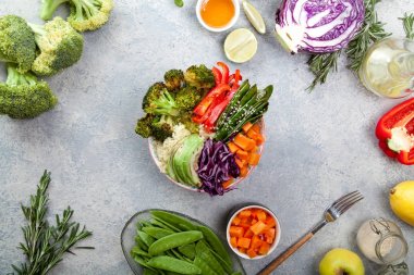 Kuskus, brokoli ve havuç pişmiş ile öğle yemeği için lezzetli sağlıklı kase küpleri, kızarmış bezelye, avokado ve kırmızı lahana kesmek. Kolay vejetaryen diyet kavramı. Rustik arka plan. Üstten Görünüm.